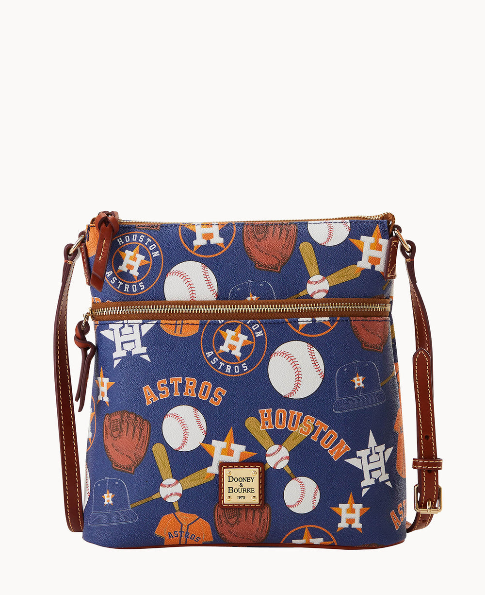 A blue crossbody bag with brown leather strap featuring Houston Astros logos, baseballs, gloves, and bats in an all-over print. The bag has a gold zipper and a Dooney & Bourke logo patch on the front.