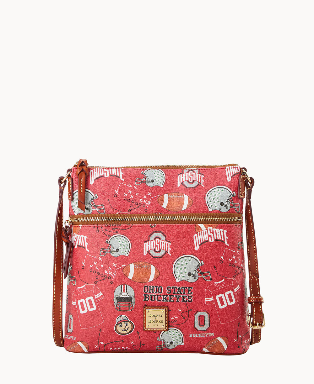 A red crossbody bag with Ohio State Buckeyes logos, football helmets, footballs, and jerseys printed on it. The bag has gold zippers, a front pocket, and a brown adjustable shoulder strap.