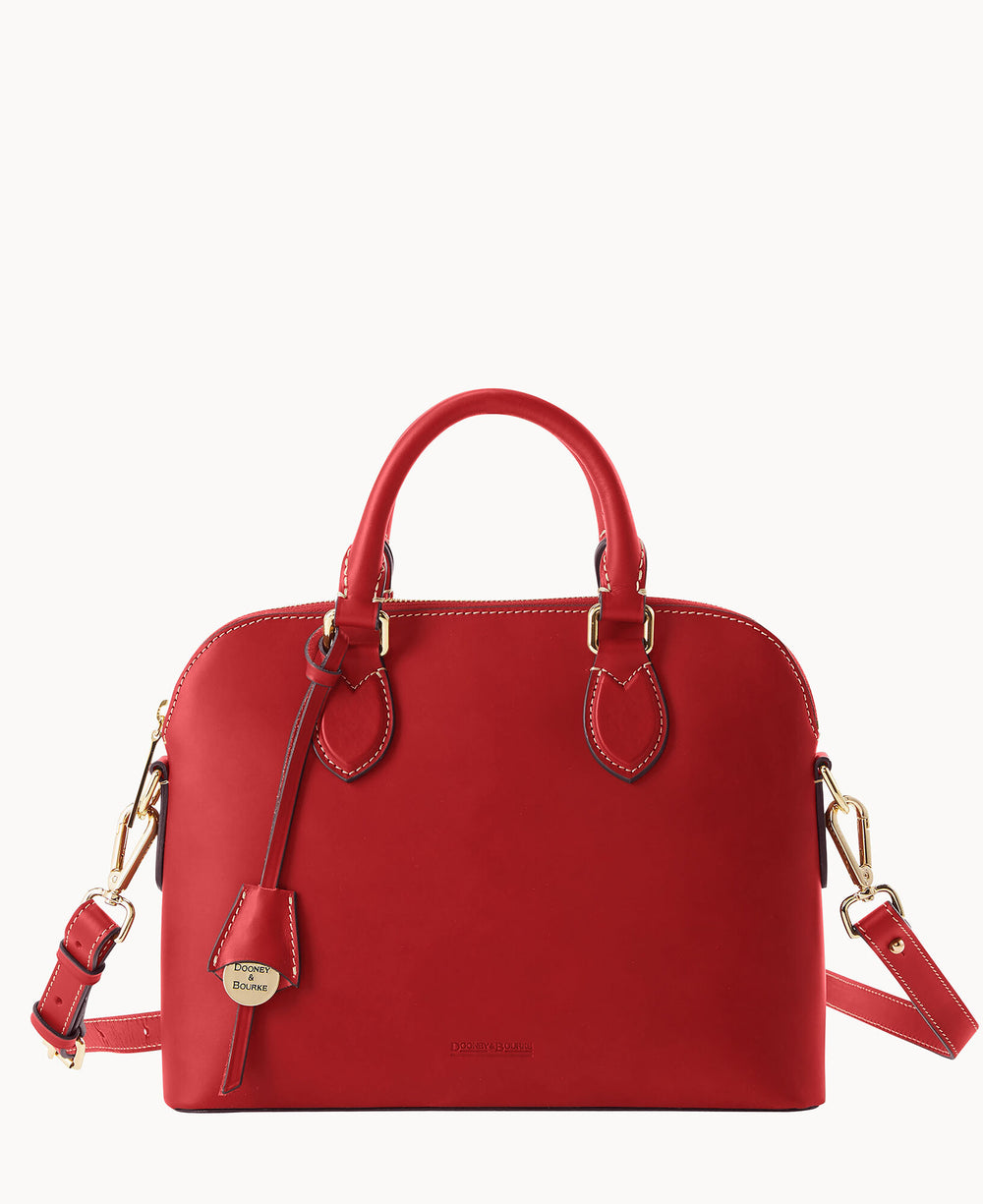 A bright red leather handbag with gold hardware, double handles, a detachable shoulder strap, and a small leather tag. The bag features white stitching and a zippered top closure.