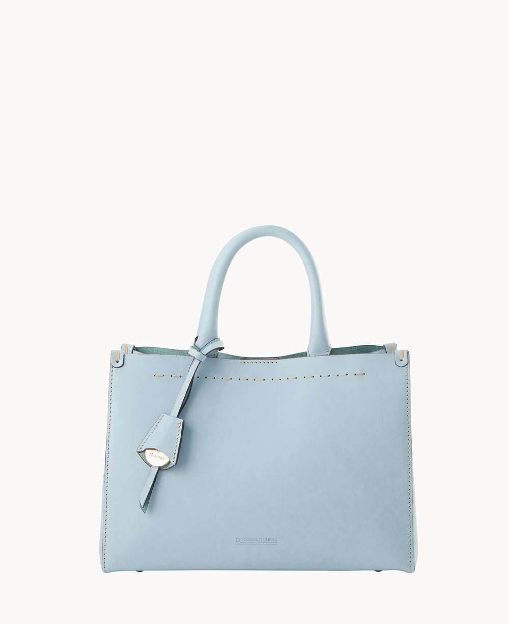 A light blue leather handbag with two handles, a decorative tag, subtle stitching details, and minimalist design, set against a plain white background.