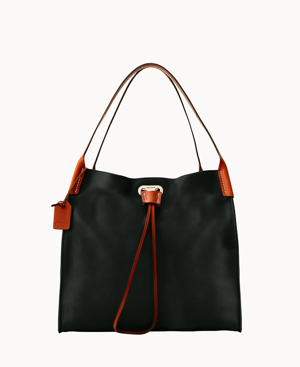 A black leather tote bag with brown leather handles and trim, featuring a matching brown luggage tag and a drawstring closure, displayed against a plain white background.