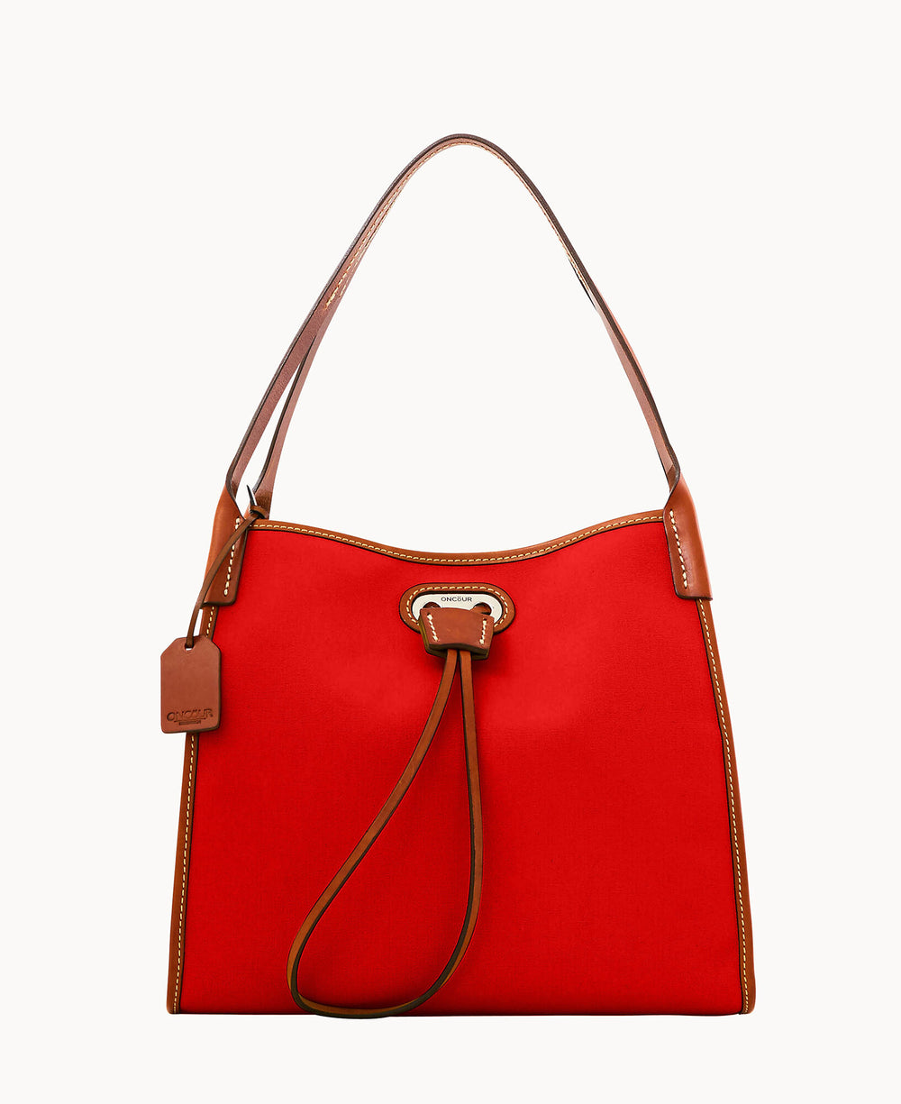 A red handbag with brown leather trim and handle, featuring a leather drawstring closure and a small leather tag attached to one side. The bag has a structured, rectangular shape.