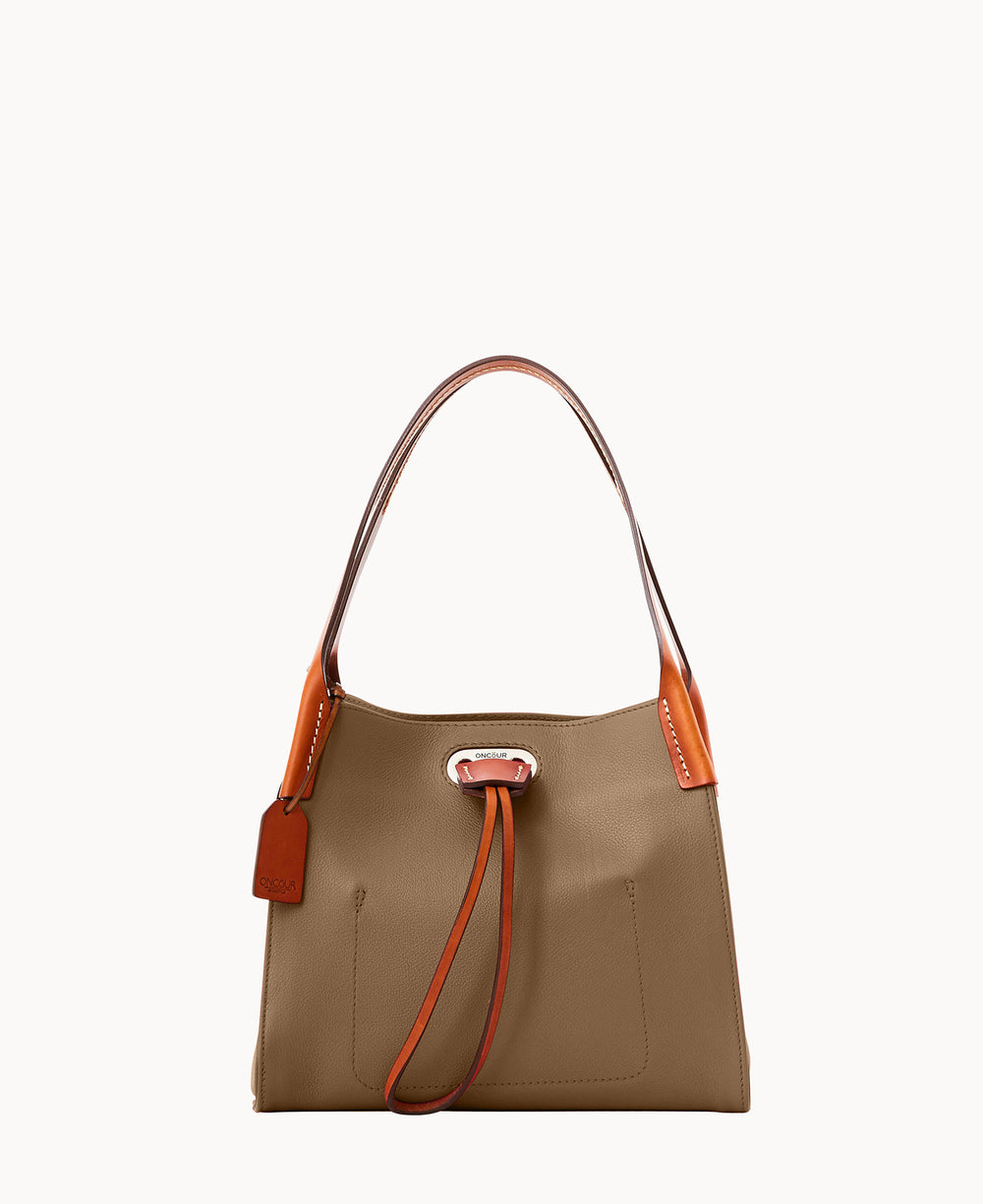 A taupe leather handbag with brown handles and accents, featuring a front pocket, decorative leather tag, and a drawstring detail on the front, photographed against a white background.