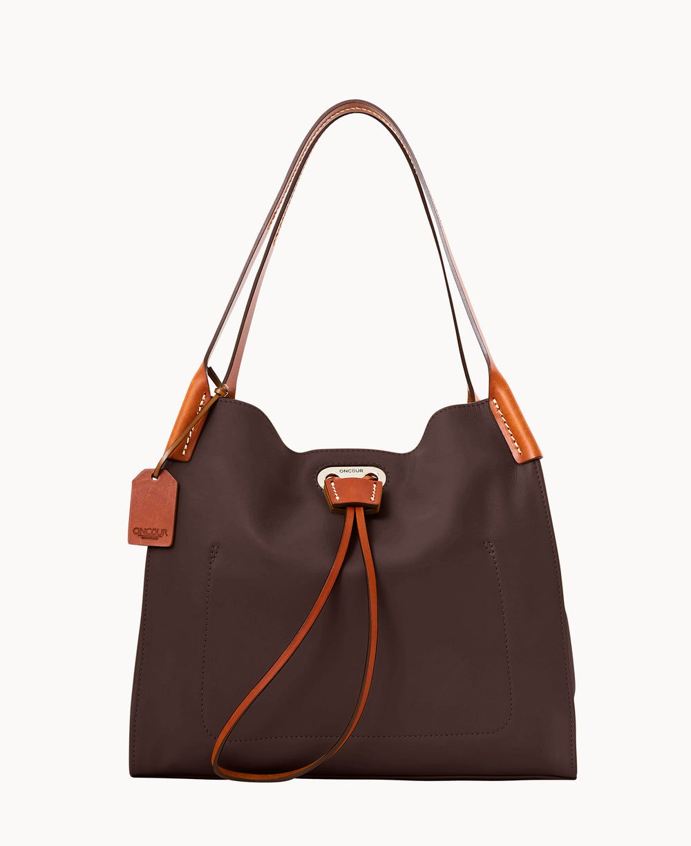 A brown leather shoulder bag with tan handles and accents, featuring a drawstring closure, front patch pockets, and a hanging tag.