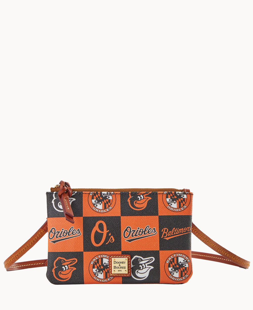 A small crossbody bag with an orange and black checkered pattern featuring various Baltimore Orioles logos and text. The bag has a brown leather strap and zipper with a Dooney & Bourke label on the front.