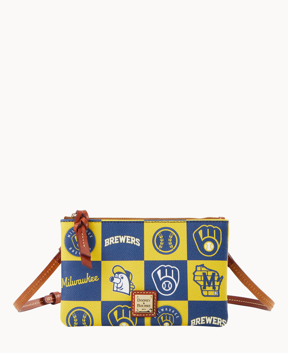 A small crossbody bag with brown leather strap, featuring a yellow and blue checkerboard pattern with Milwaukee Brewers logos and baseball-themed graphics. The bag has a zip closure and a Dooney & Bourke label on front.