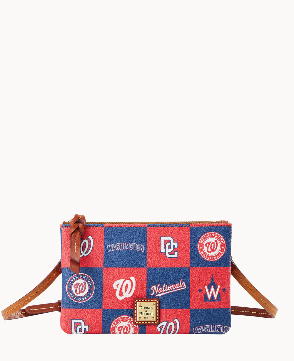 A small crossbody bag with a brown strap, featuring a red and blue checkerboard pattern with various Washington Nationals baseball team logos and the Dooney & Bourke label on the front.