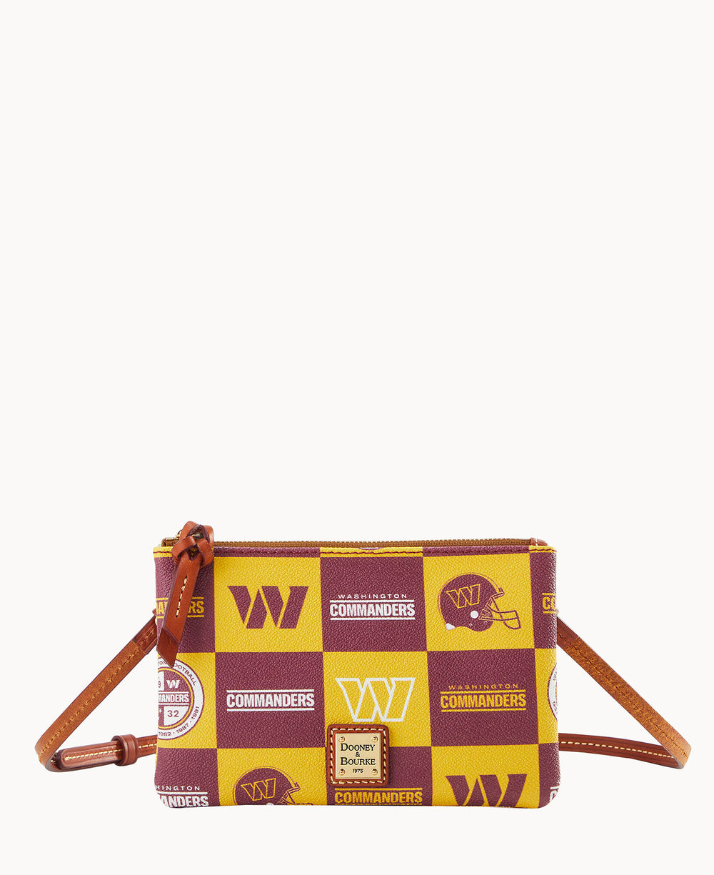 A small crossbody bag with a brown leather strap, featuring a yellow and burgundy patchwork design with Washington Commanders logos and football helmet graphics. The bag has a zipper closure and Dooney & Bourke label.