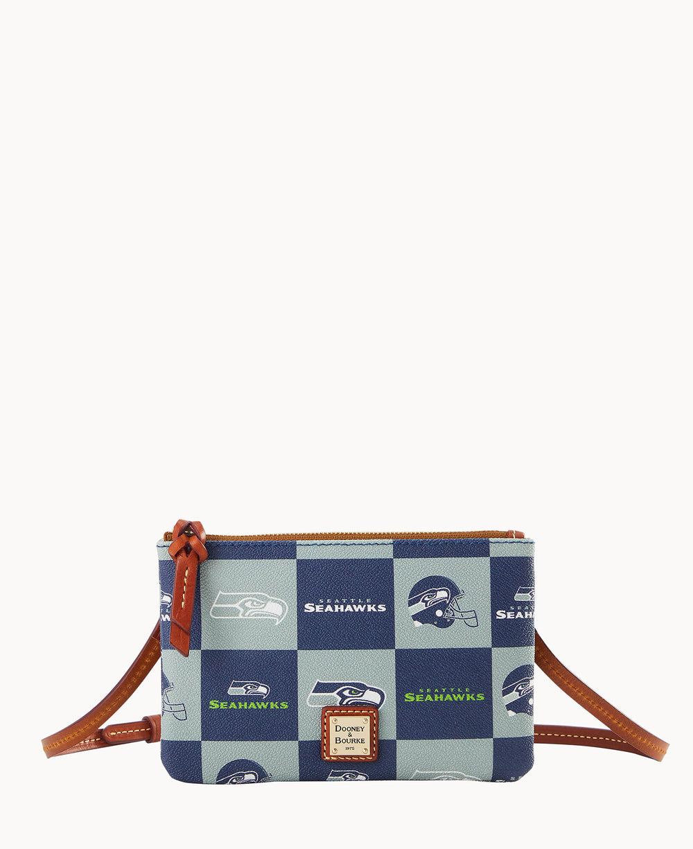 A small crossbody purse with a brown strap, featuring a blue and green checkered pattern with Seattle Seahawks logos, and a Dooney & Bourke label on the front.