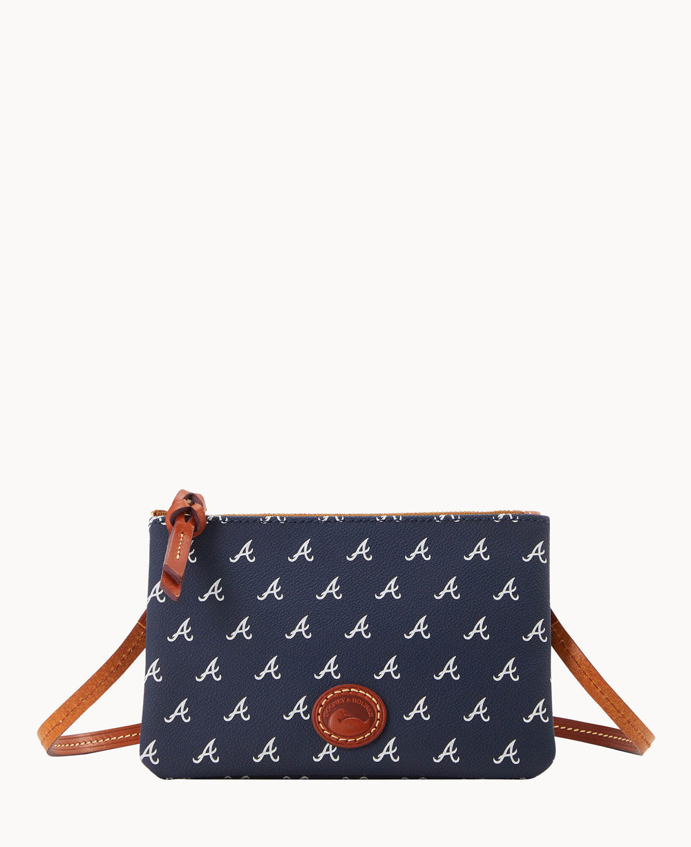 A navy blue crossbody bag patterned with repeating white â€œAâ€ logos, featuring brown leather trim, a zip closure with a leather pull, and an oval leather patch on the front.