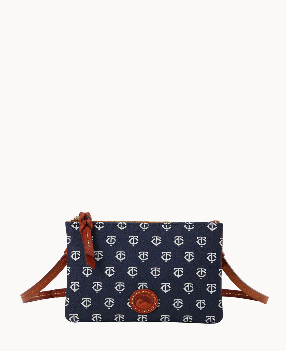 A small navy blue crossbody bag with a white repeating pattern, brown leather trim, zipper closure, and a brown leather strap.