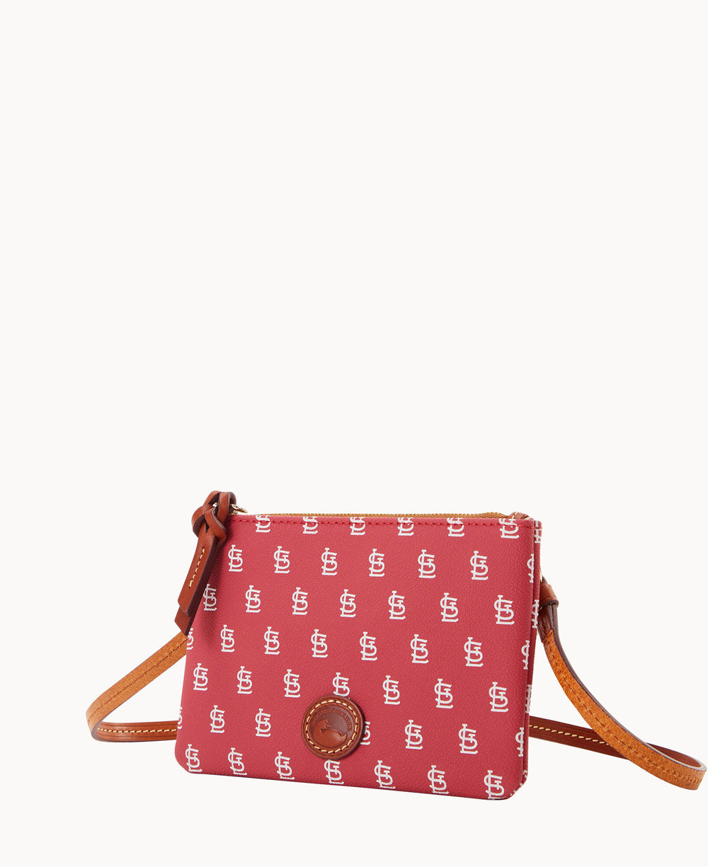 A red crossbody bag with a brown strap, decorated with a repeating white St. Louis Cardinals logo and a round leather patch on the front.