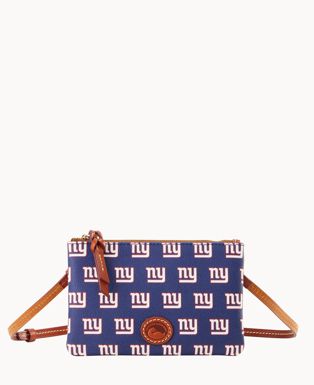 A blue crossbody bag with a repeating white and red ny logo pattern, brown leather accents, a zipper closure, and a small brown leather logo patch on the front.