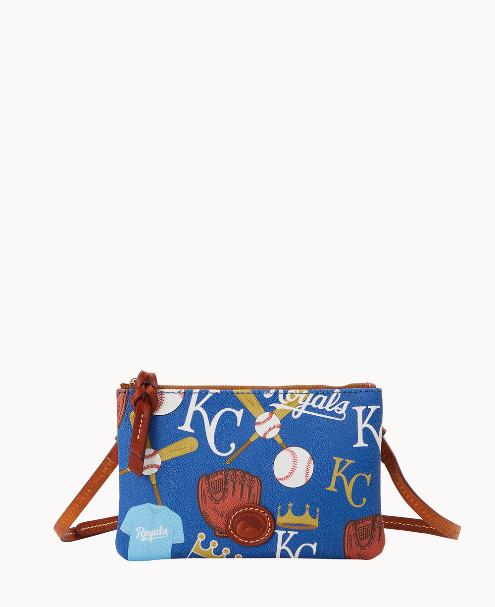 A small blue crossbody bag decorated with Kansas City Royals baseball-themed graphics, including baseballs, gloves, bats, crowns, and KC letters, with brown leather trim and strap.