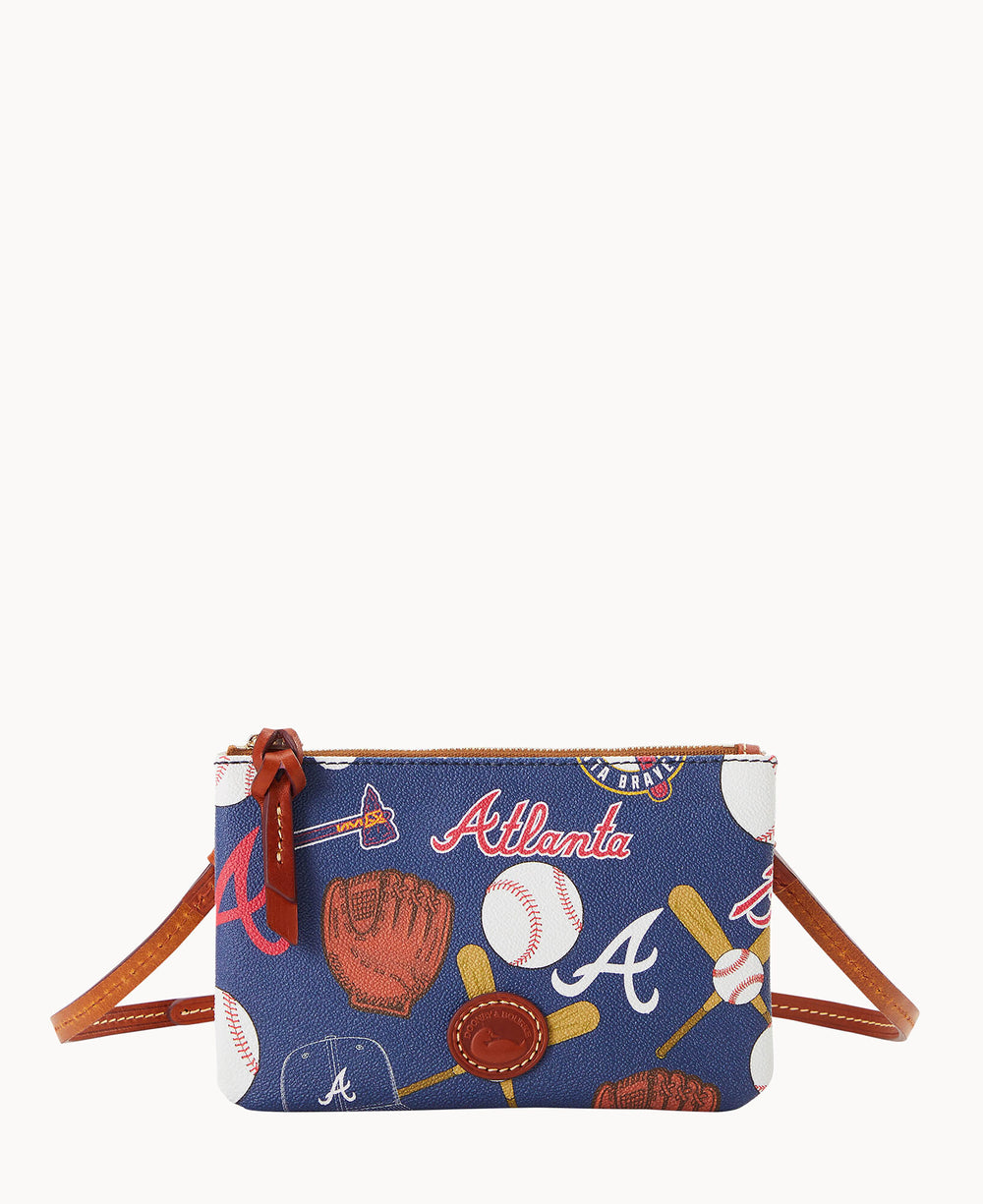 A small crossbody bag with a blue background featuring baseball-themed graphics, including bats, gloves, baseballs, and â€œAtlantaâ€ text. The bag has brown leather accents and a zipper closure.