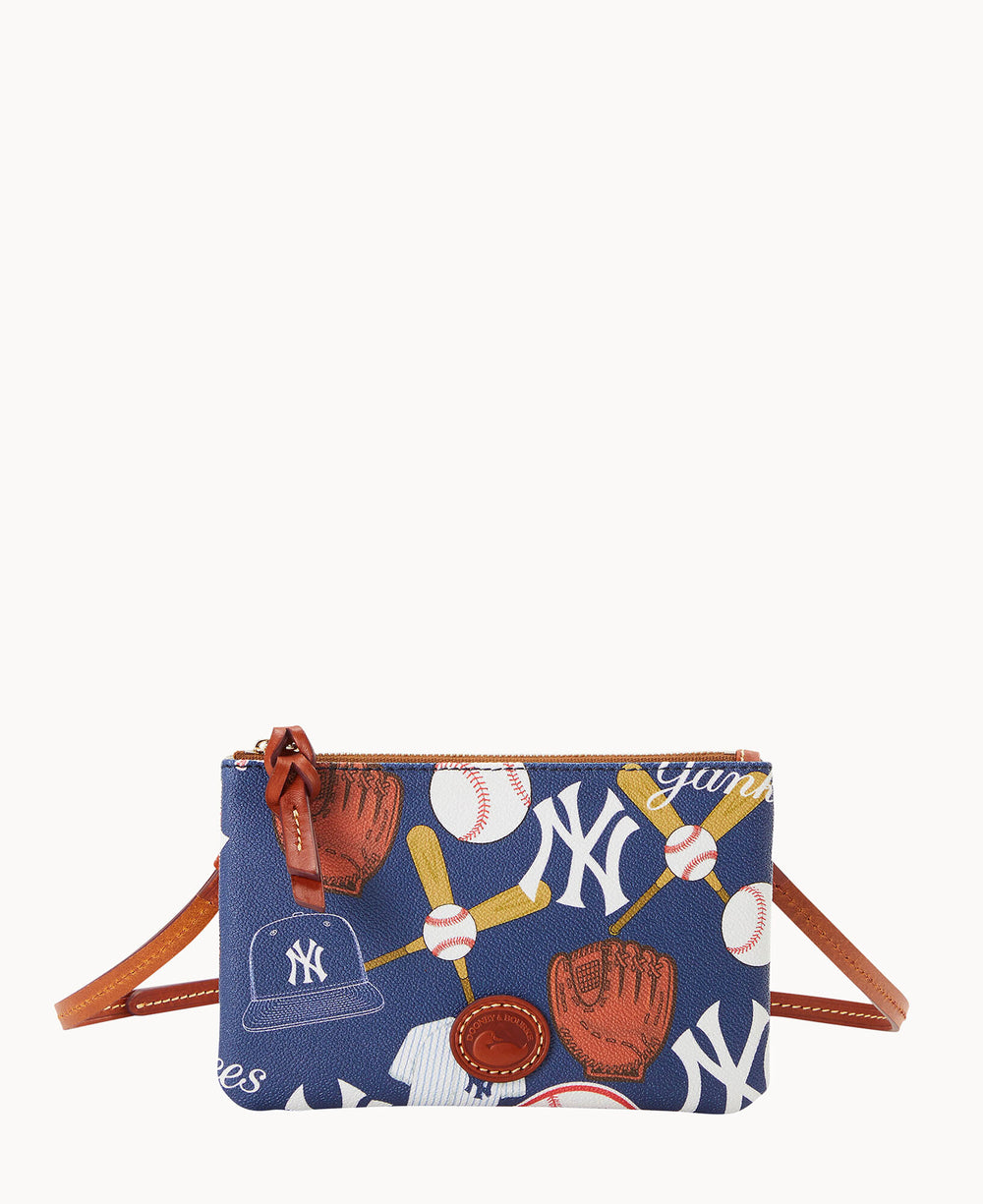 A small blue crossbody bag with brown leather accents, featuring printed images of baseballs, bats, gloves, a cap, and New York Yankees logos in white.