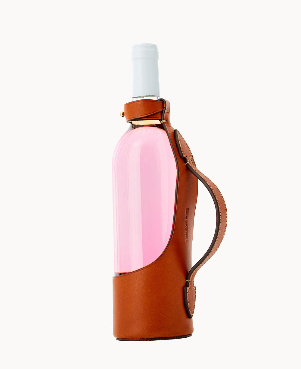 A bottle with pink liquid is partially wrapped in a stylish brown leather holder with a handle, against a plain white background.