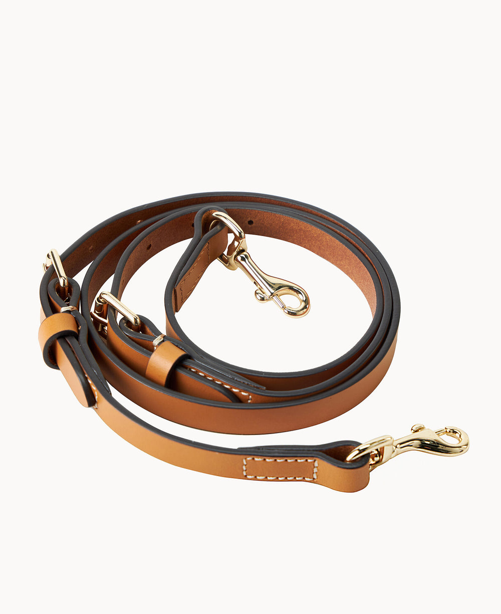 A coiled brown leather dog leash with gold metal clips and white stitching, displayed on a white background.