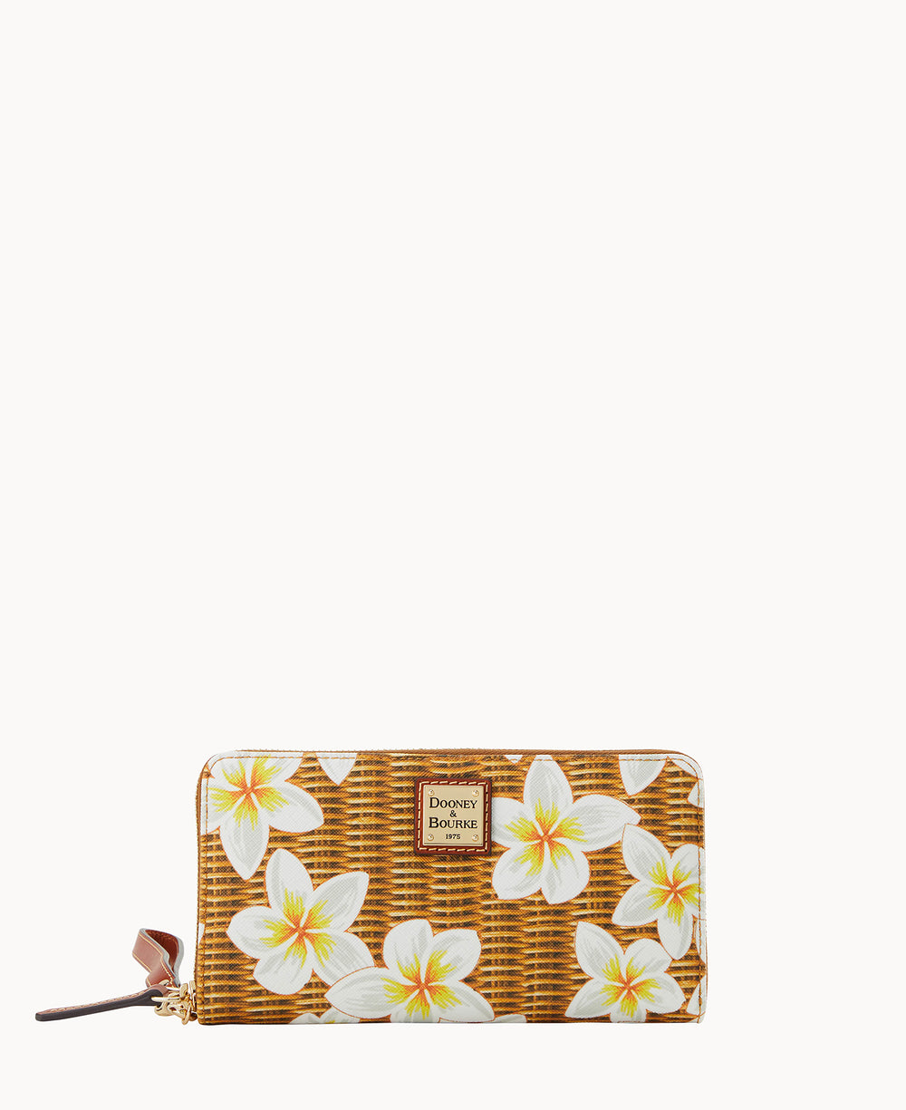 A rectangular wallet with a brown woven pattern, decorated with large white and yellow plumeria flowers. It has a gold zipper, brown wrist strap, and a metal Dooney & Bourke logo plate on the front.