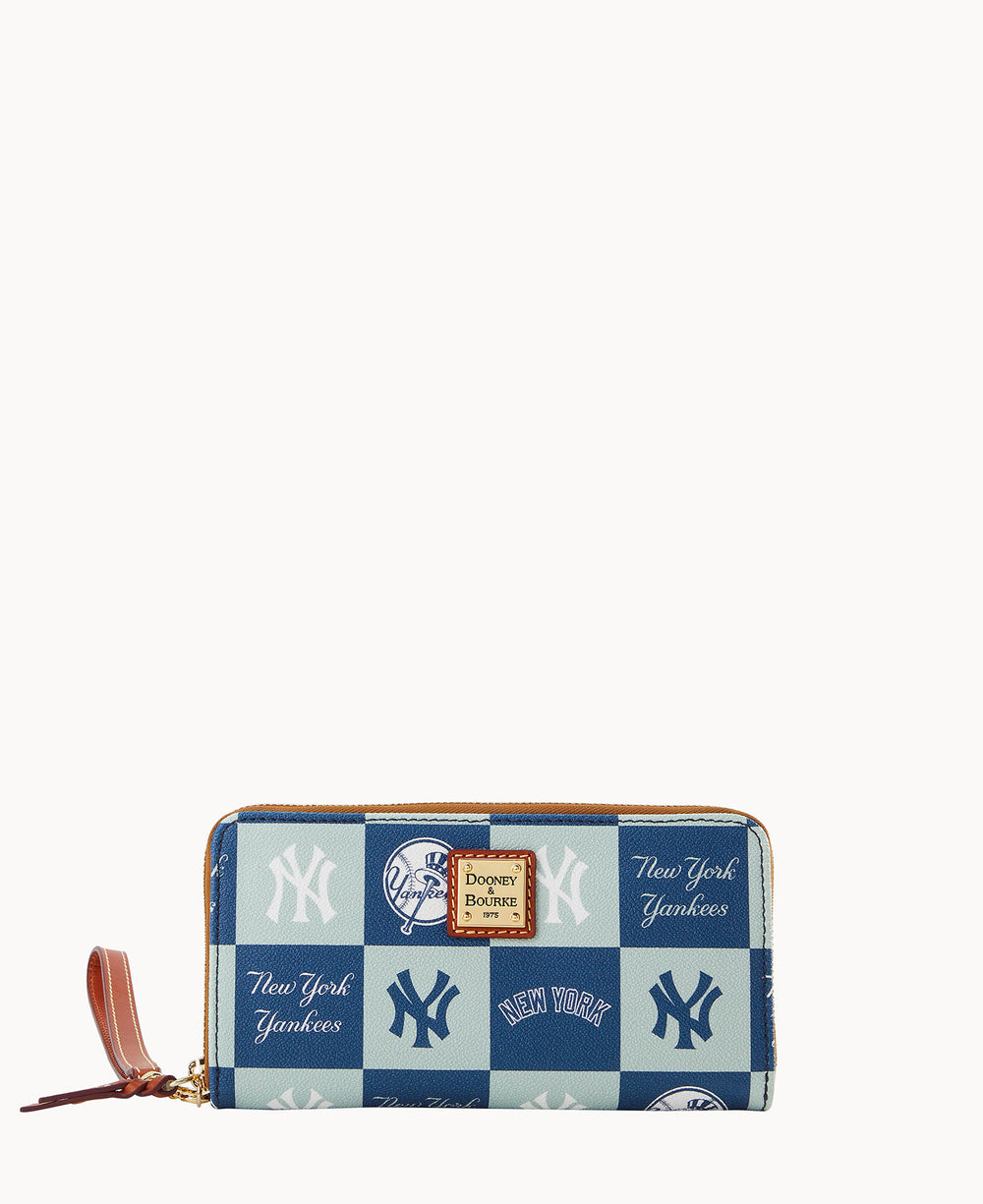A rectangular zip-around wallet featuring a blue and teal New York Yankees checkerboard pattern with team logos and script, and a Dooney & Bourke leather logo patch on the front.