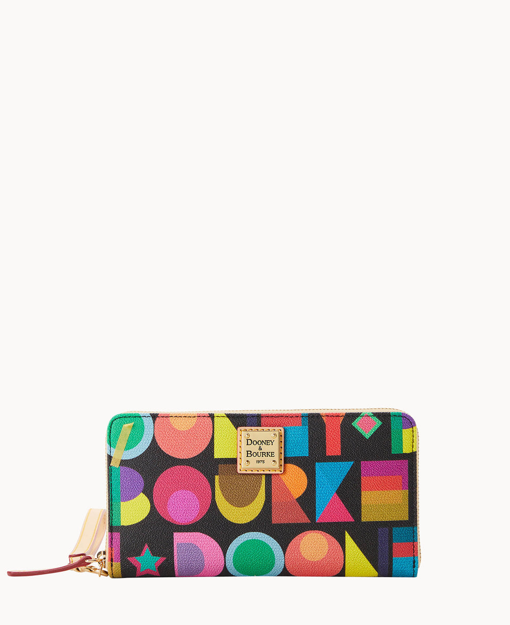 A rectangular Dooney & Bourke wallet with a zip closure, featuring a colorful geometric pattern and bold letters on a black background, and a gold logo plate in the center.