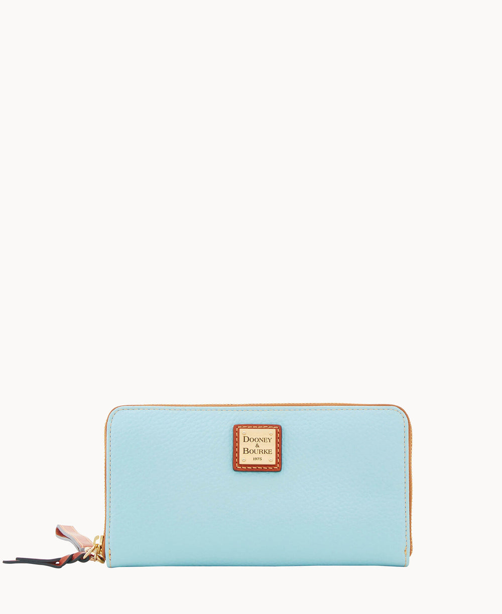 A light blue zip-around wallet with a gold zipper and a small rectangular Dooney & Bourke logo plaque in the center. The wallet has a simple, elegant design and is photographed against a white background.