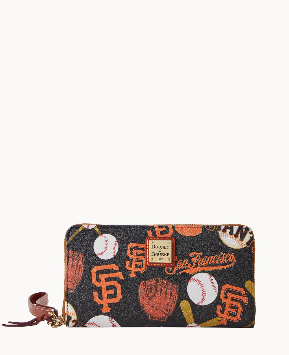 A zippered wallet with San Francisco Giants logos, baseballs, gloves, bats, and San Francisco text in orange and white on a black background. The wallet has a brown leather zipper pull.