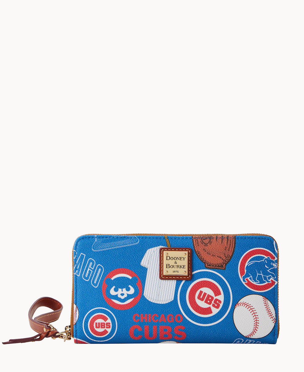 A blue zip-around wallet featuring Chicago Cubs logos, baseball-themed graphics, and a brown leather wrist strap. The front displays a Dooney & Bourke label.