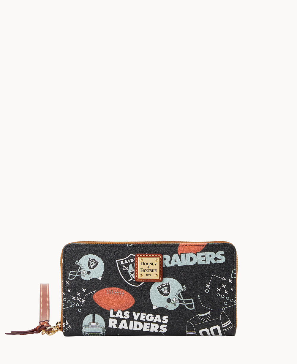 A black zippered wallet featuring Las Vegas Raiders logos, football helmets, and football graphics, with a brown leather wrist strap and a gold Dooney & Bourke label on the front.
