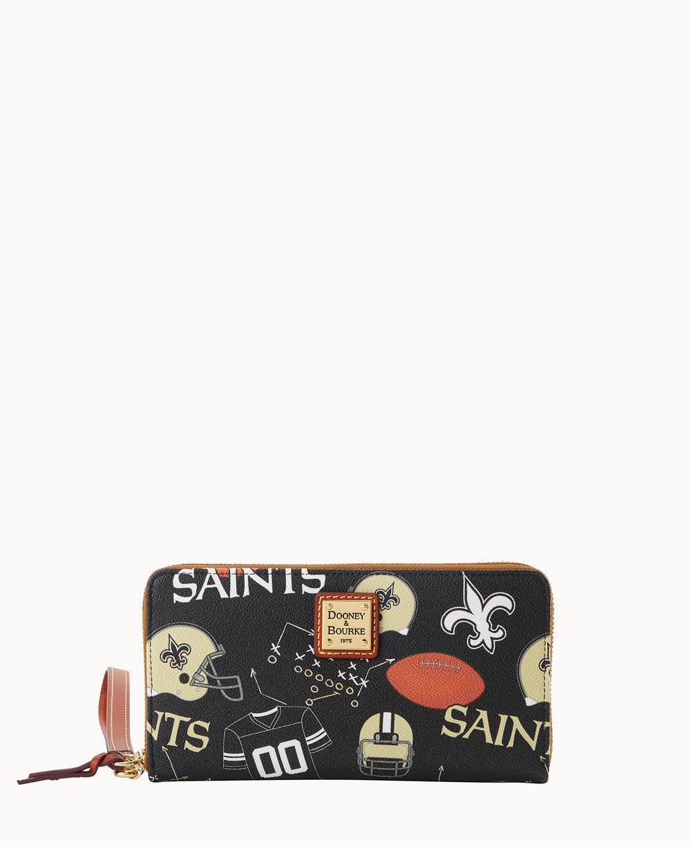A black Dooney & Bourke wallet featuring New Orleans Saints logos, football helmets, jerseys, footballs, and the word â€œSAINTSâ€ in various fonts and sizes, with a tan zipper and leather pull tab.