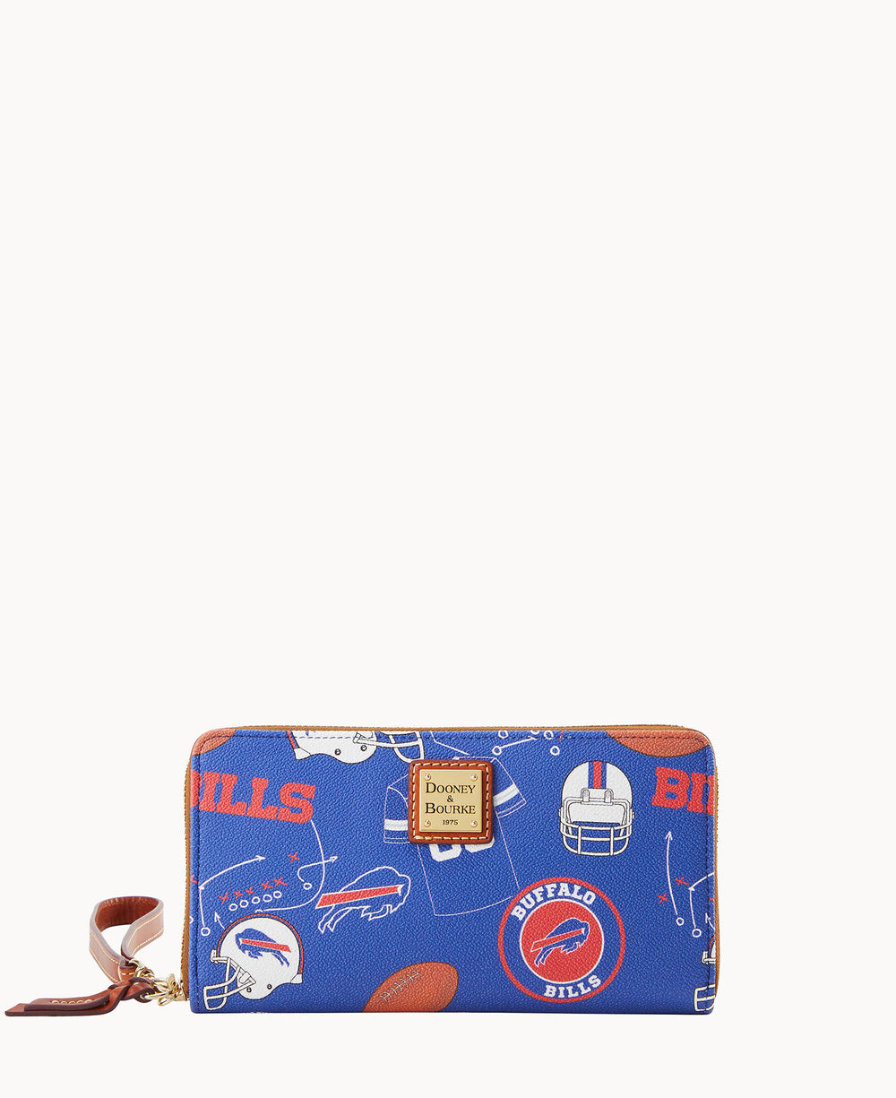 A blue Dooney & Bourke zip wallet features Buffalo Bills logos, footballs, helmets, and â€œBILLSâ€ text, with a tan leather wrist strap and gold logo plate on the front.