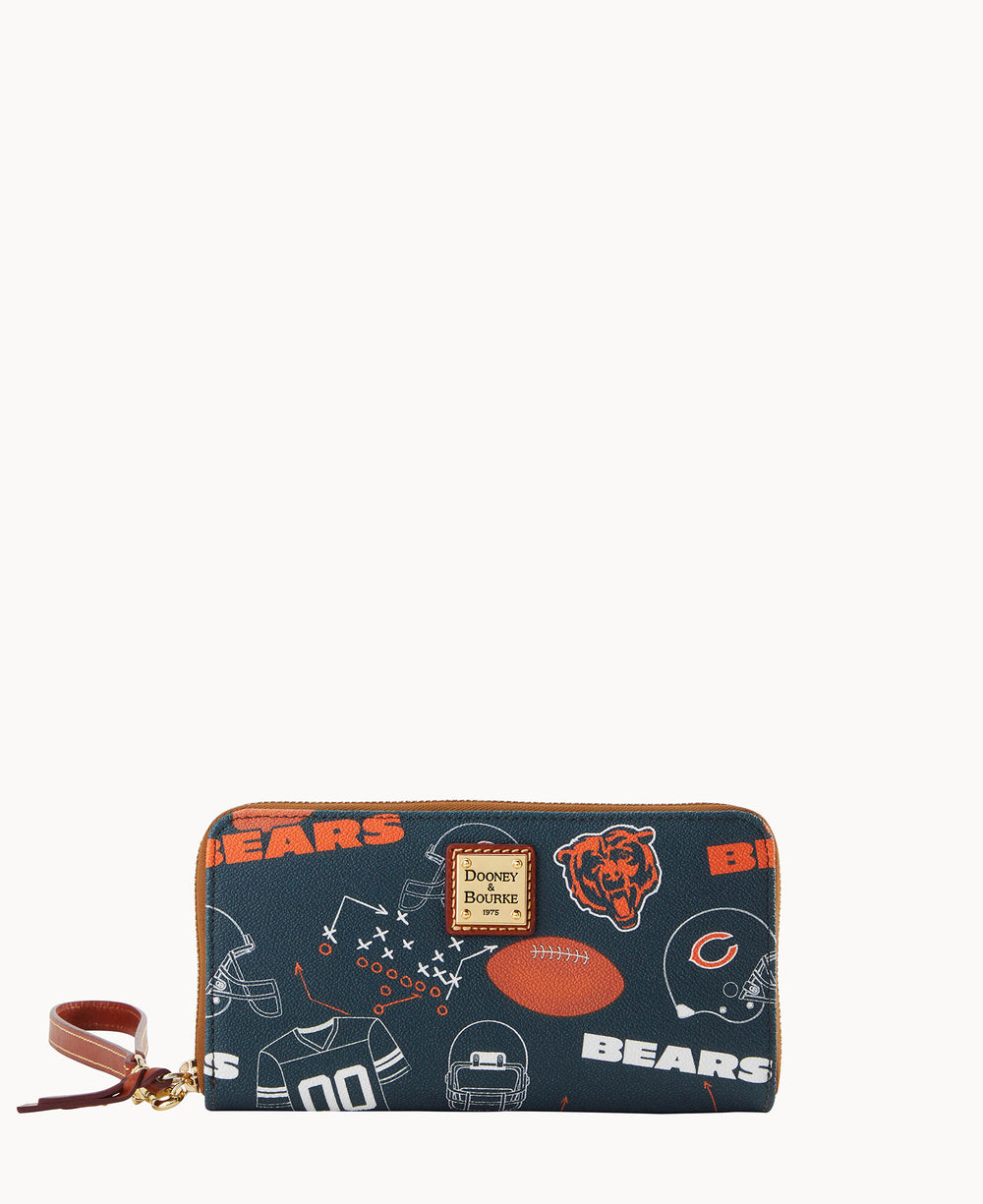A navy blue wallet featuring Chicago Bears logos, helmets, jerseys, footballs, play diagrams, and the word Bears in orange. The wallet has a brown zipper and a Dooney & Bourke label on the front.