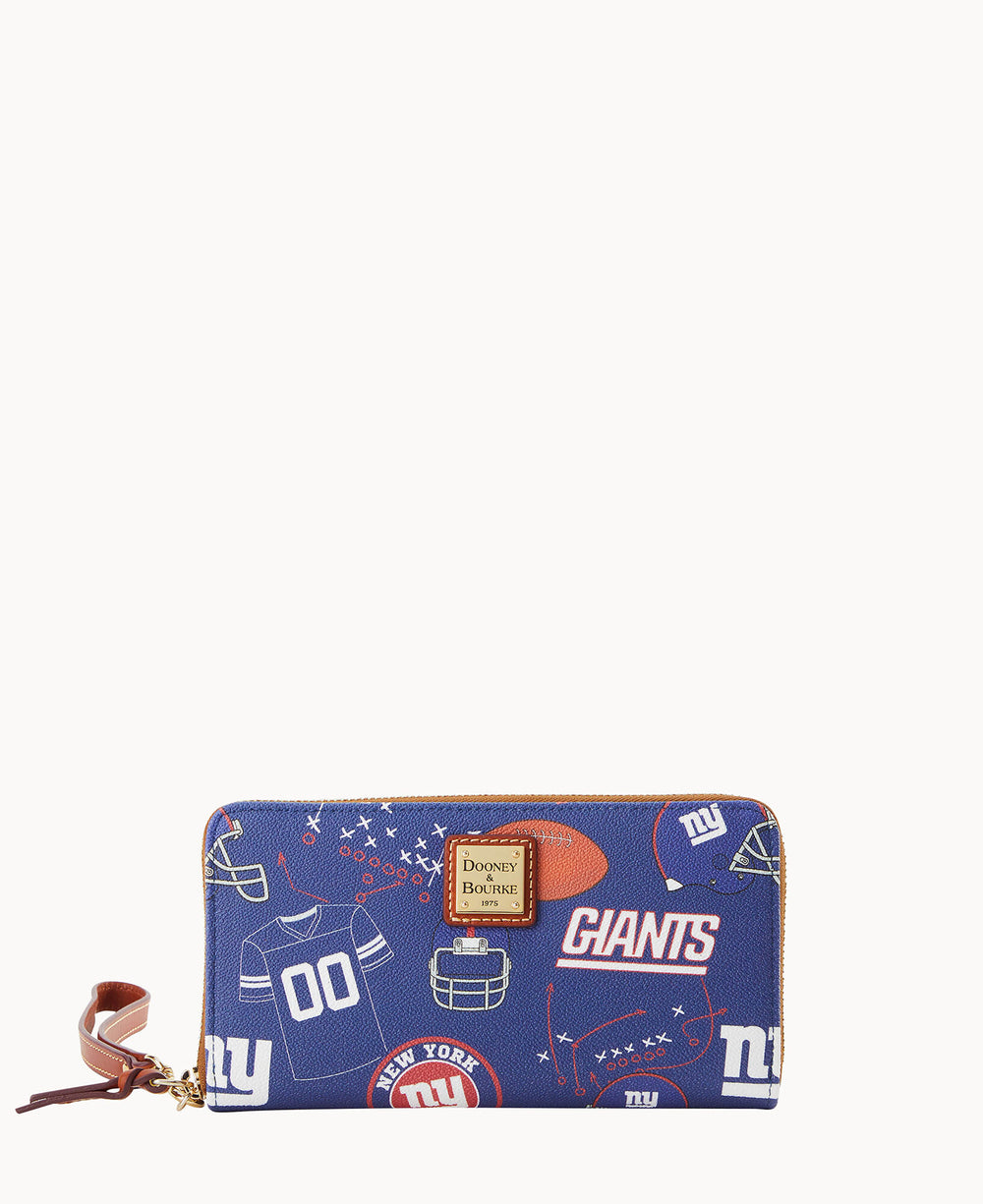 A blue zippered wallet decorated with New York Giants football-themed graphics, including helmets, jerseys, footballs, and the NY and Giants logos. A gold Dooney & Bourke label is on the front.