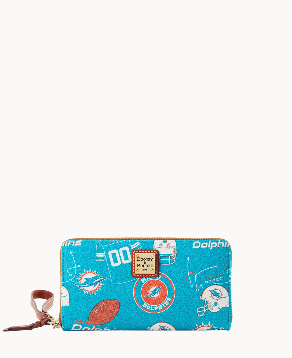 A blue Dooney & Bourke zip wallet with Miami Dolphins football team logos, helmets, jerseys, and football graphics, featuring a brown wrist strap and gold label on the front.