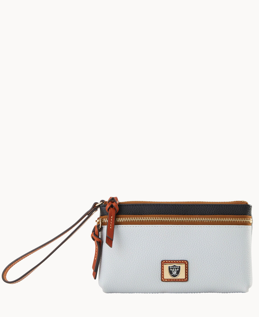 A white wristlet pouch with brown leather accents, a gold zipper, and a small gold and brown logo plate on the front. The pouch has a detachable wrist strap.