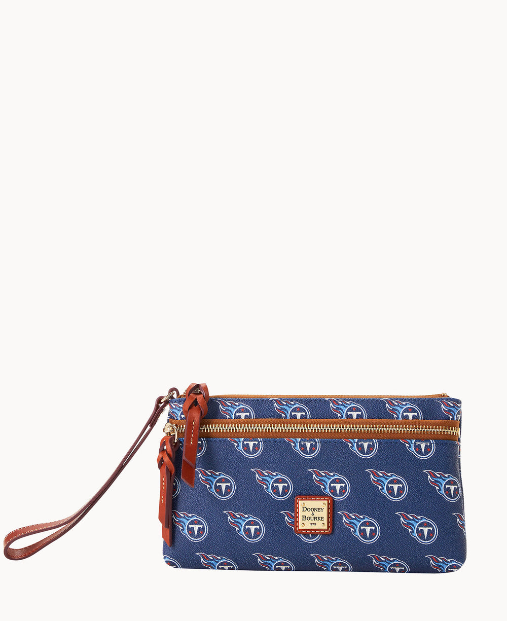 A navy wristlet pouch with the Tennessee Titans logo pattern, brown leather zipper pulls, a brown wrist strap, and a small rectangular Dooney & Bourke label on the front.