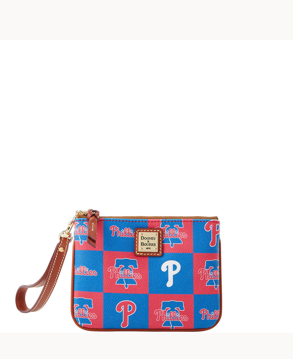 A small wristlet bag with a brown leather strap, featuring a red and blue checkerboard pattern with â€œPhilliesâ€ and â€œPâ€ logos, and a Dooney & Bourke label on the front.