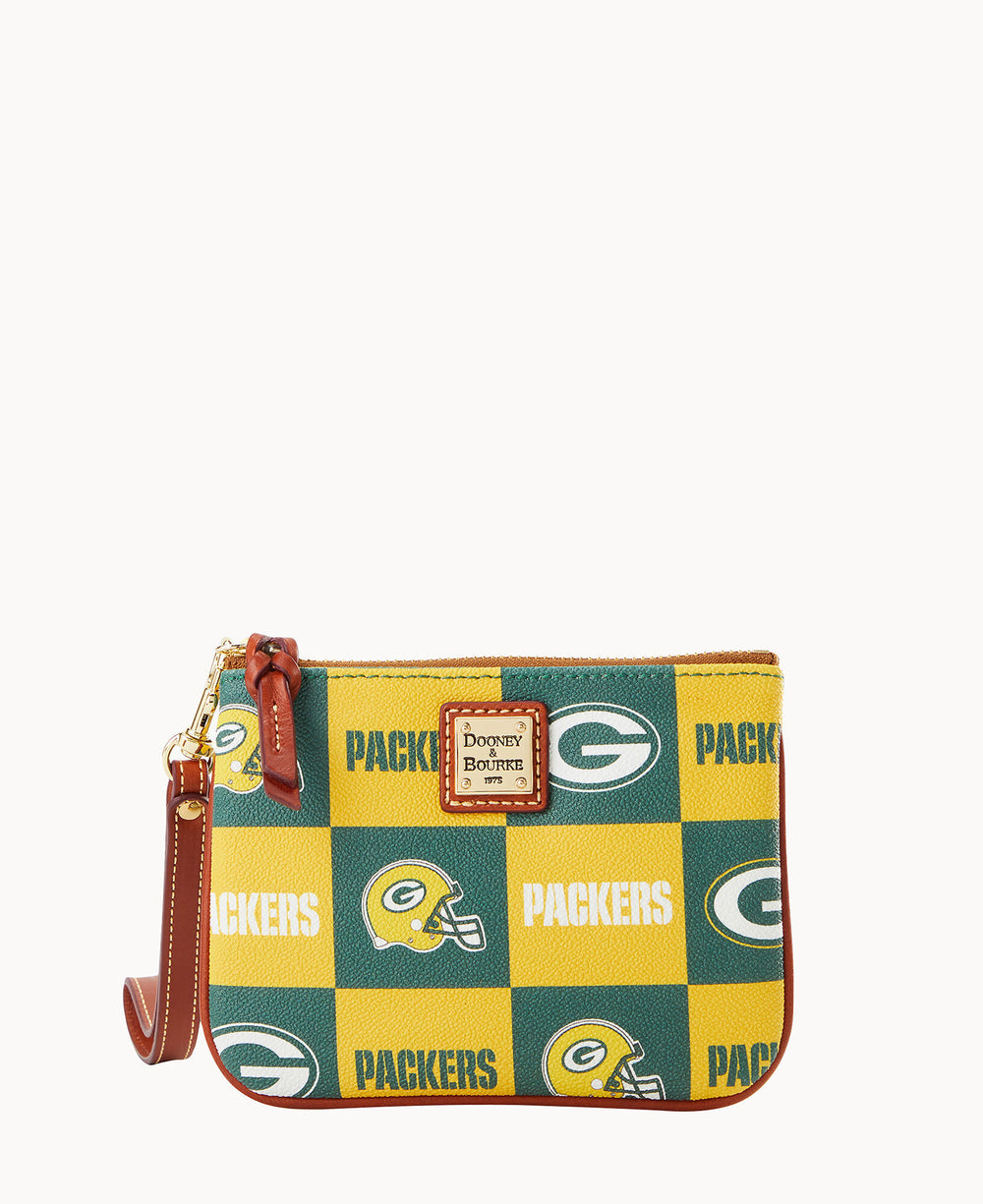 A small wristlet pouch with a brown leather strap, featuring a green and yellow checkered pattern with the Green Bay Packers logo, football helmet, and the word PACKERS. A Dooney & Bourke label is on the front.