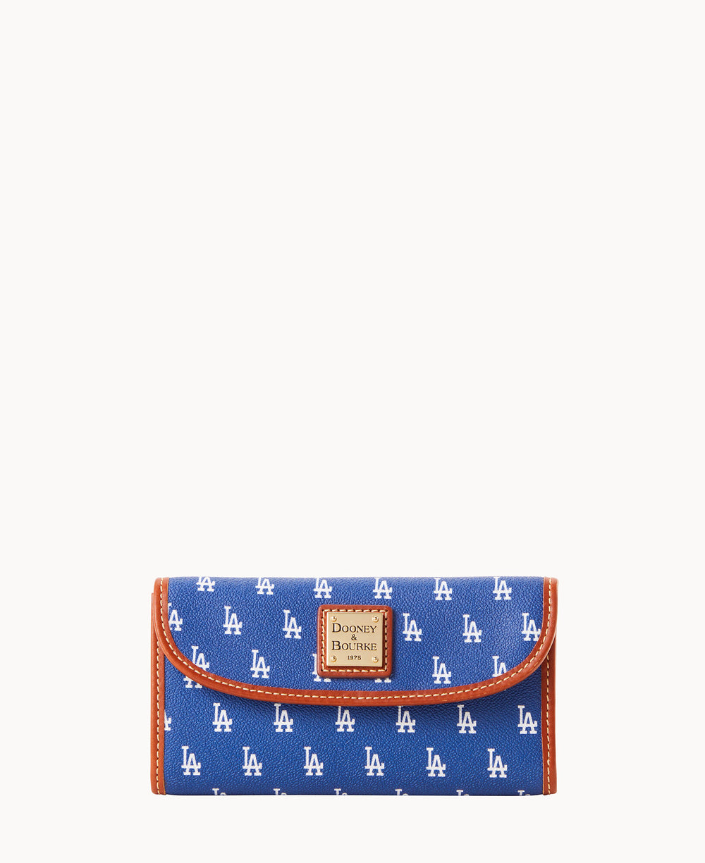 A blue Dooney & Bourke wallet featuring an all-over white LA pattern and tan trim, with a brown leather Dooney & Bourke logo patch on the front, displayed against a white background.