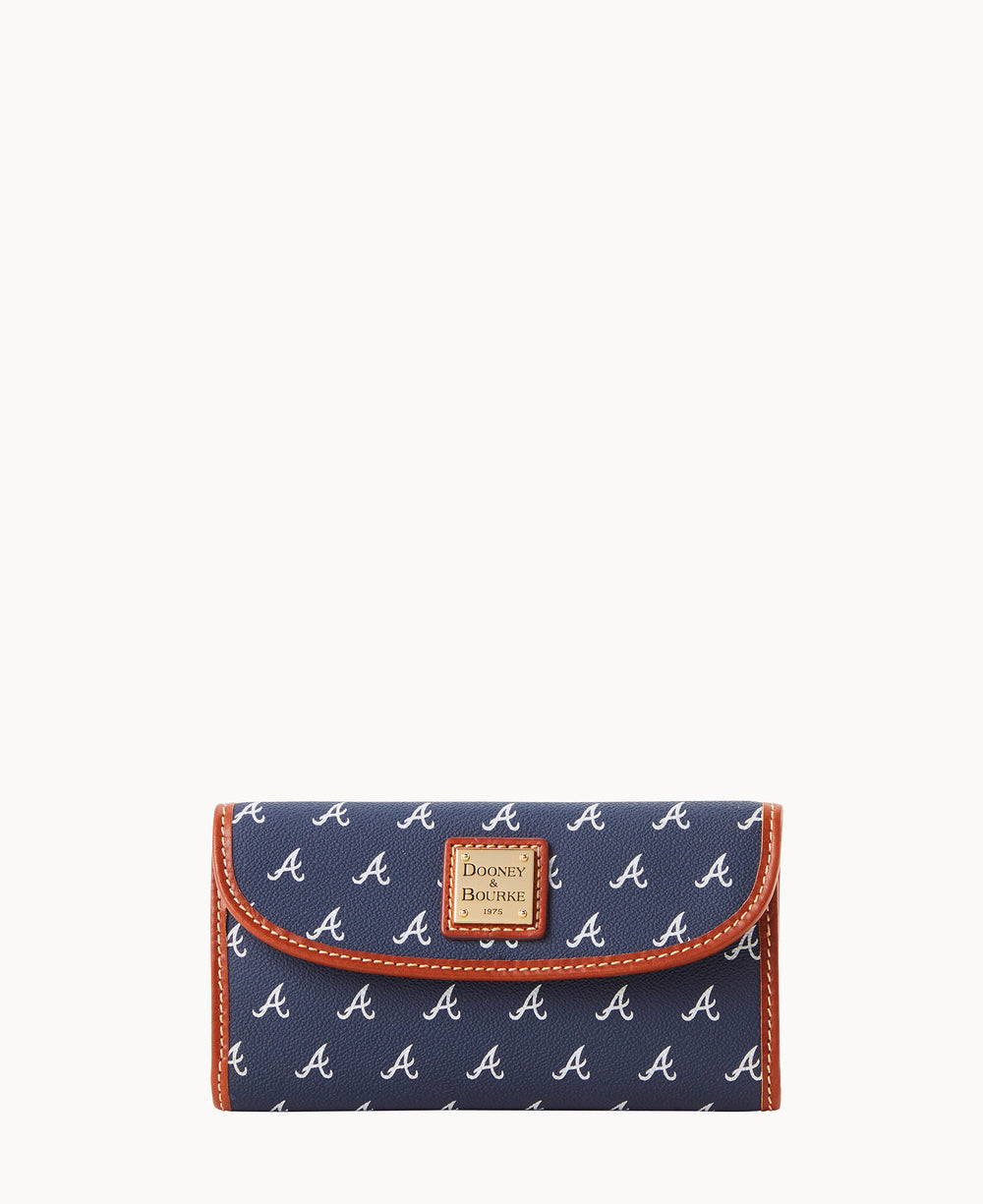 A navy blue wallet with a repeating white â€œAâ€ pattern, brown trim, and a Dooney & Bourke label on the front flap.