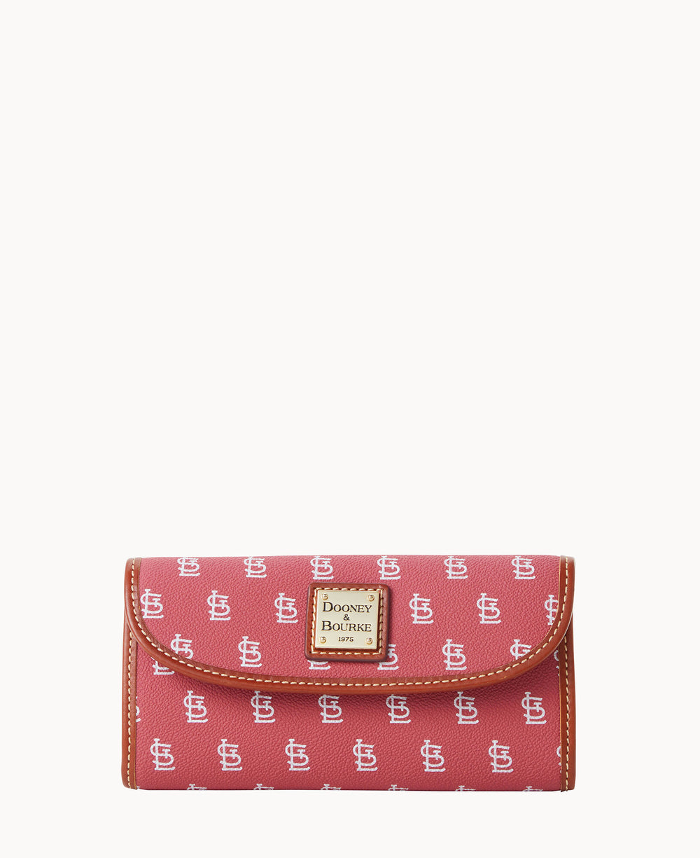 A red Dooney & Bourke wallet with a repeating white logo pattern and brown trim, featuring a gold label on the front.