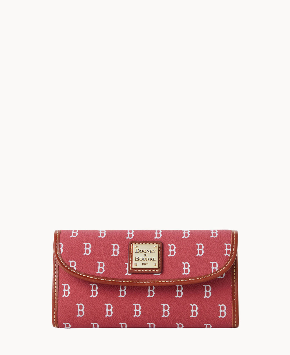 A red Dooney & Bourke wallet featuring a repeating white â€œBâ€ pattern and brown trim, with a gold-tone logo plate on the front flap against a plain white background.
