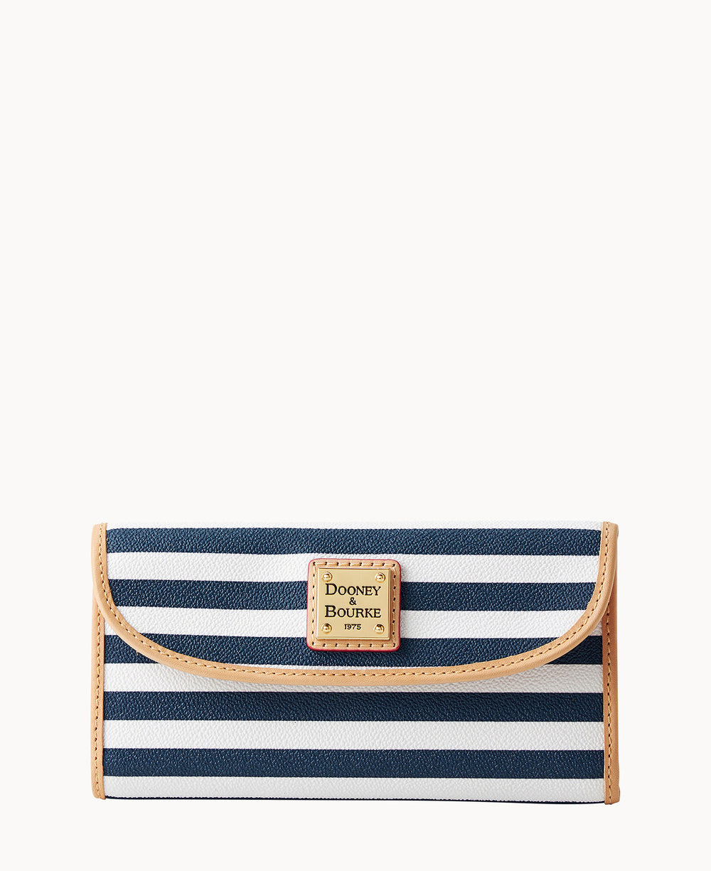 A navy blue and white striped wallet with tan trim. The wallet features a rectangular gold label on the front reading â€œDooney & Bourke 1975.â€ The background is plain white.