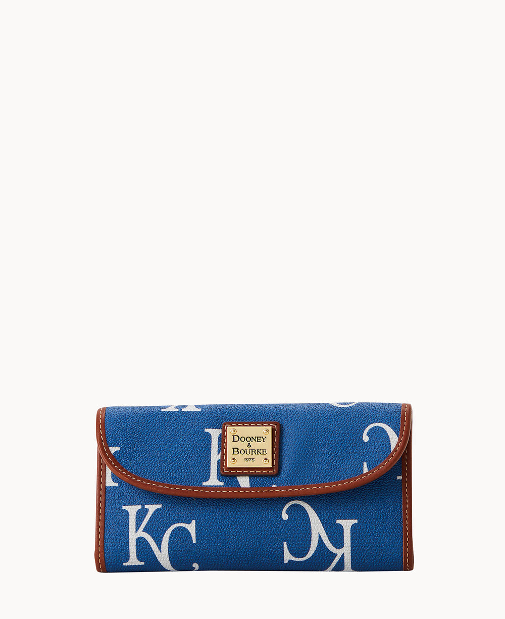 A blue Dooney & Bourke wallet with large white letters KC printed on it, brown trim, and a small leather logo patch on the front.