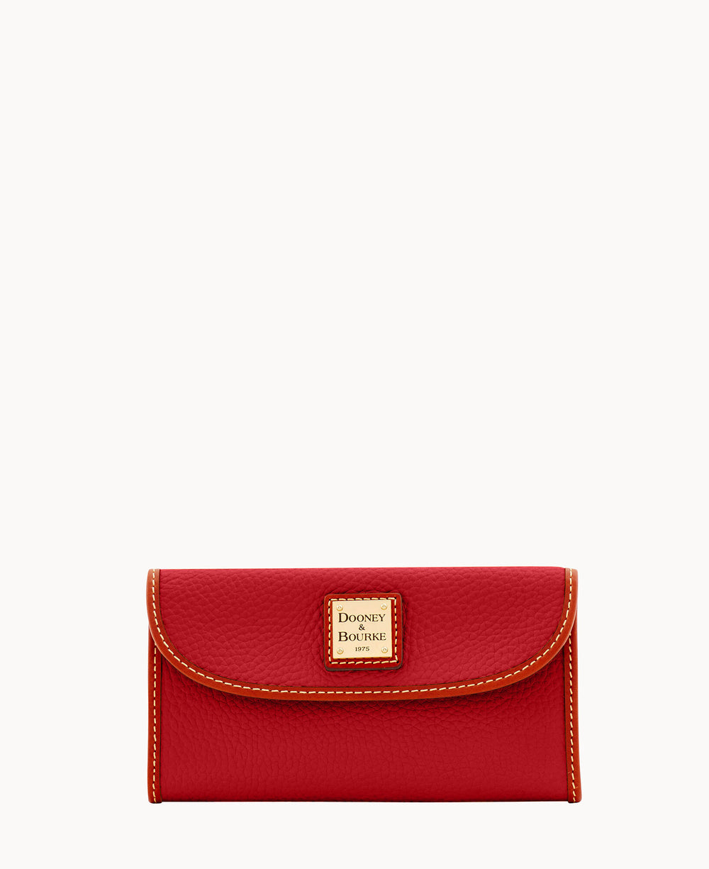 A red leather wallet with contrast stitching and a gold-tone Dooney & Bourke logo plate on the front flap, set against a plain white background.