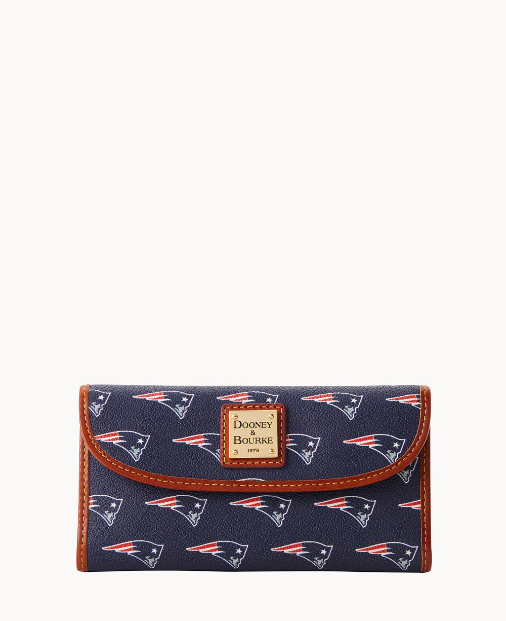 A navy blue wallet with brown trim, featuring a repeating New England Patriots logo pattern and a Dooney & Bourke label on the front flap.