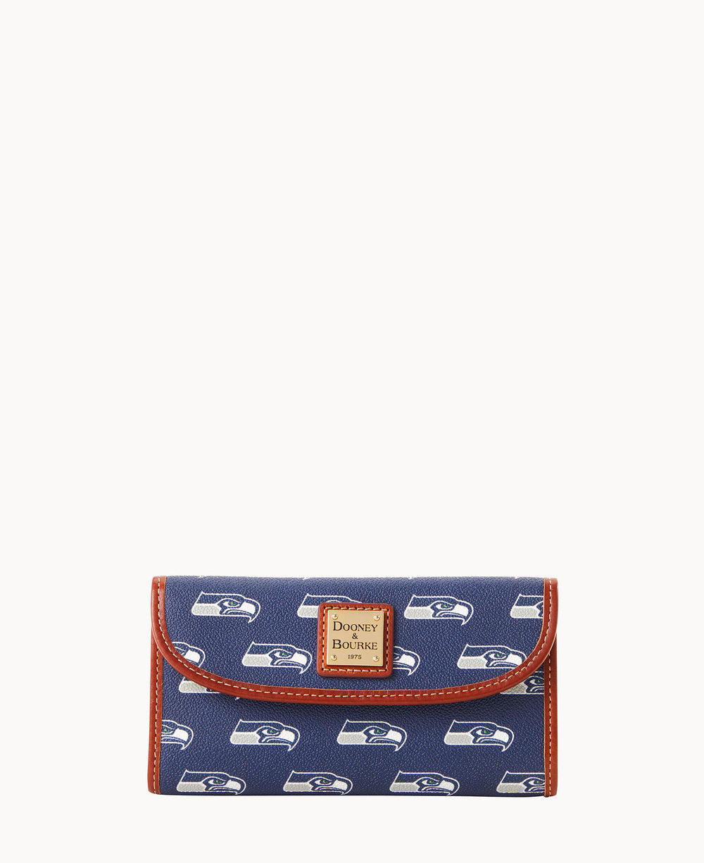 A blue wallet with brown trim featuring repeating Seattle Seahawks logos and a Dooney & Bourke label on the front.