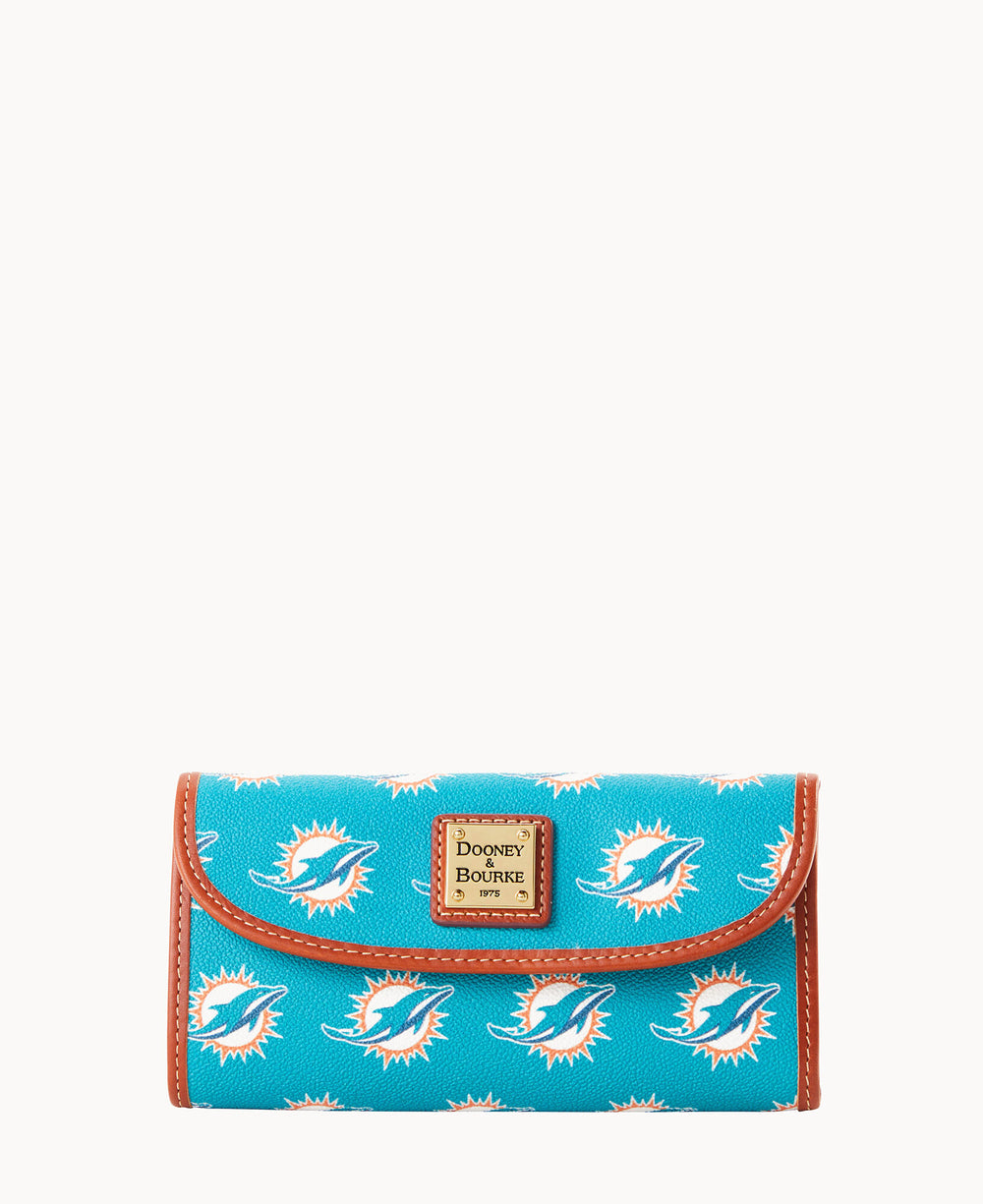 A turquoise Dooney & Bourke wallet features the Miami Dolphins logo pattern, brown trim, and a gold label on the front, photographed on a white background.